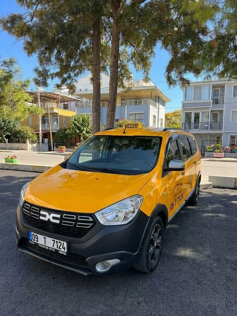 Didim Munzur Taksi'nin sarı Dacia Lodgy taksisi, Didim'de ağaçların gölgesinde